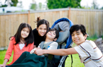children surrounding child in wheelchair